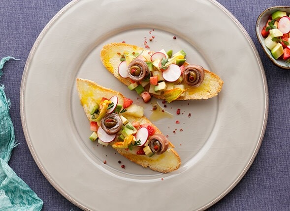 Pane croccante con tartare di frutta, verdura e alici con oliva