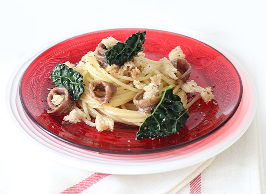 Spaghetti con alici, mollica di pane croccante, chips di cavolo nero e colatura di alici