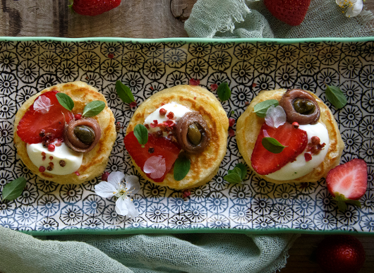 Mini pancake al parmigiano con fragole e alici con cappero