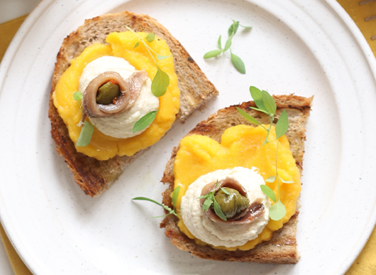 Bruschetta con crema di zucca, formaggio spalmabile e filetti di alici alla Mediterranea